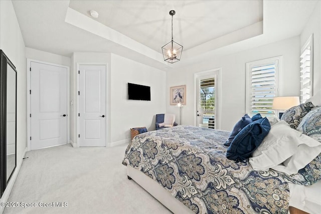 carpeted bedroom with baseboards, a chandelier, a raised ceiling, and multiple windows