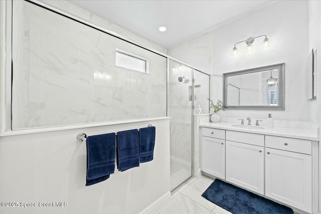 full bath with marble finish floor, vanity, and a marble finish shower