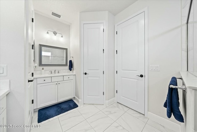 bathroom featuring baseboards, visible vents, marble finish floor, and vanity
