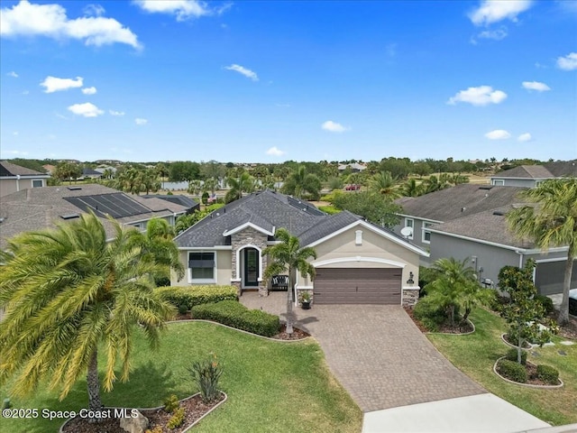 single story home with a front lawn, a residential view, stucco siding, driveway, and a garage