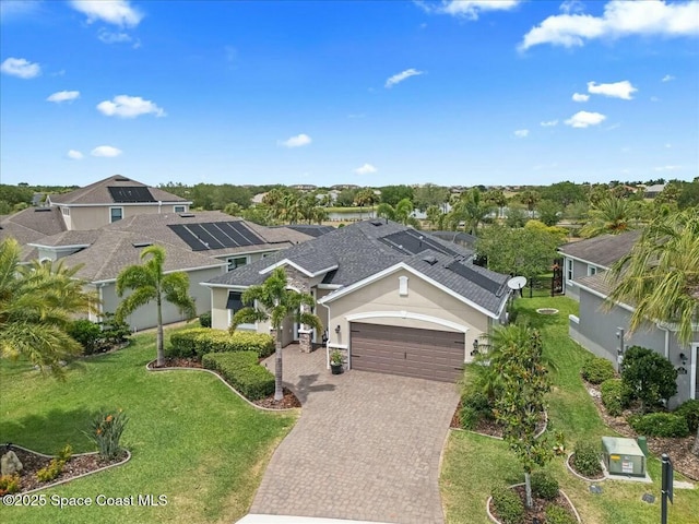 view of front of house with roof with shingles, a front lawn, a garage, stucco siding, and decorative driveway