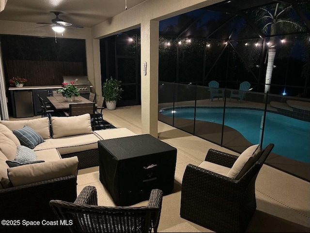 pool at night featuring a ceiling fan, a grill, a patio, a fenced in pool, and an outdoor hangout area