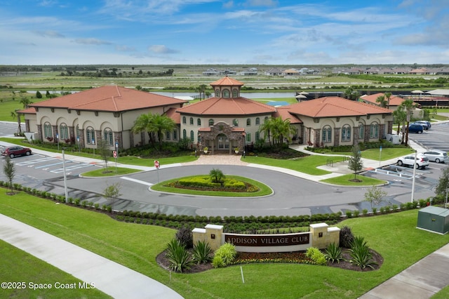 exterior space featuring a gazebo, a yard, a water view, and uncovered parking