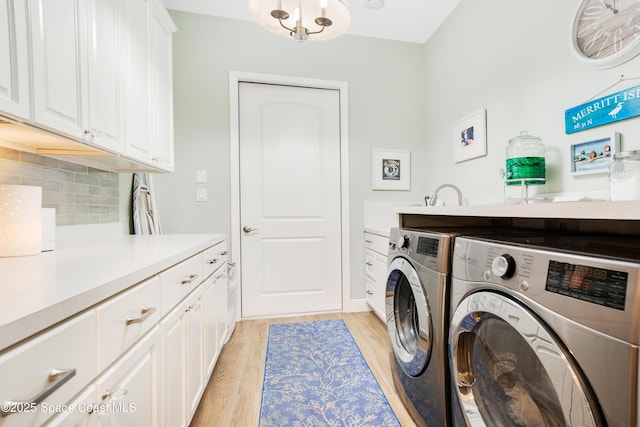 laundry area with washer and dryer, cabinet space, and light wood-style flooring