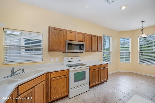6921 Abbeyville Rd, Melbourne, FL 32940 - kitchen with electric stove, stainless steel microwave, brown cabinetry, light tile patterned floors, and light countertops