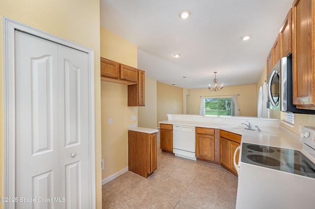 6921 Abbeyville Rd, Melbourne, FL 32940 - kitchen featuring a sink, brown cabinets, a notable chandelier, a peninsula, and white appliances