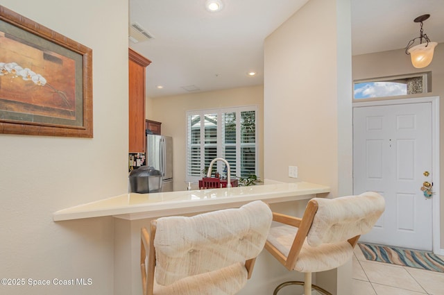 3321 San Jacinto Cir, Sanford, FL 32771 - interior space with visible vents, freestanding refrigerator, light tile patterned flooring, a breakfast bar area, and a sink