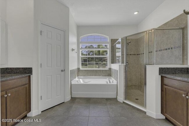 bathroom featuring vanity, a shower stall, tile patterned floors, and a bath