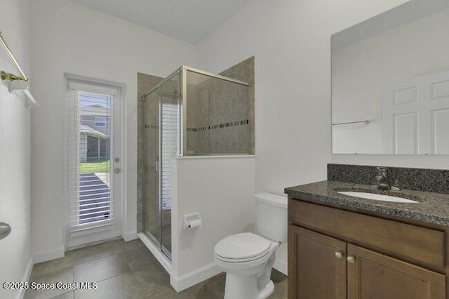 full bath featuring tile patterned floors, a shower stall, baseboards, and vanity