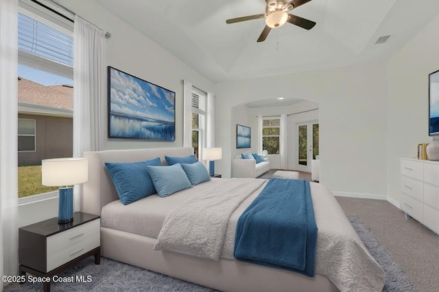 bedroom featuring french doors, a ceiling fan, visible vents, arched walkways, and carpet flooring