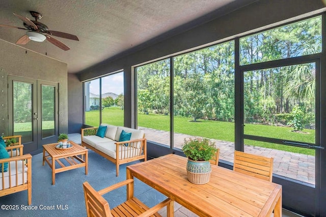 sunroom with ceiling fan, outdoor lounge area, and french doors