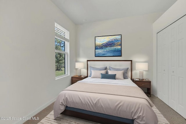 carpeted bedroom with baseboards and a closet