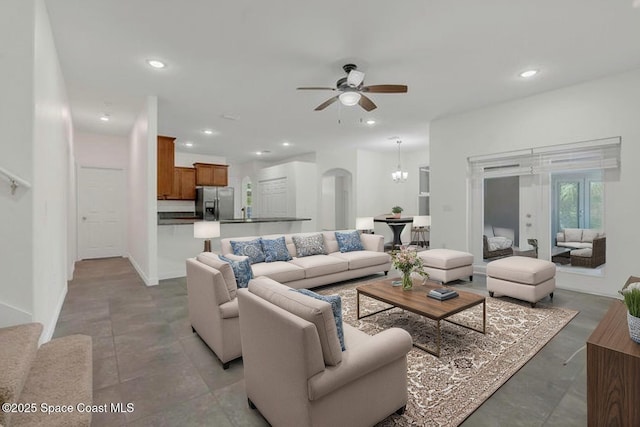 living area with recessed lighting, arched walkways, and ceiling fan with notable chandelier