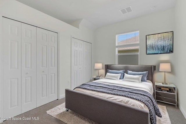 bedroom featuring multiple closets, baseboards, carpet flooring, and visible vents