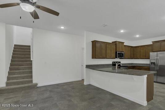 kitchen with ceiling fan, dark countertops, a peninsula, stainless steel appliances, and recessed lighting