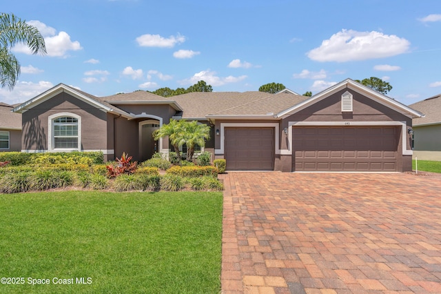 single story home with a garage, stucco siding, decorative driveway, and a front yard