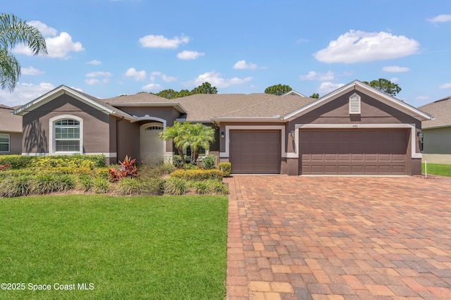 ranch-style house with decorative driveway, a garage, a front lawn, and stucco siding