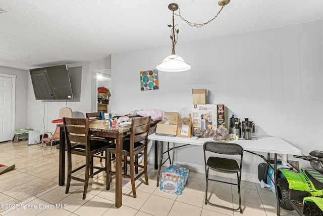dining area featuring a textured ceiling and light tile patterned floors
