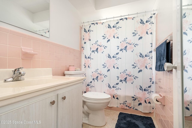 285 Hickory Ave, Merritt Island, FL 32953 - bathroom featuring tile walls, toilet, vanity, wainscoting, and speckle patterned floor