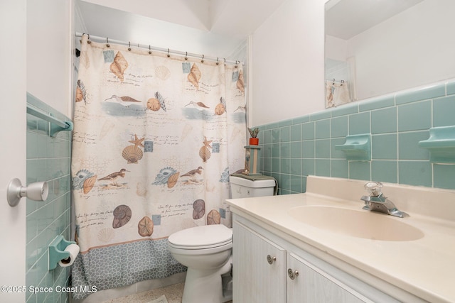 285 Hickory Ave, Merritt Island, FL 32953 - bathroom featuring vanity, toilet, tile walls, a shower with curtain, and wainscoting