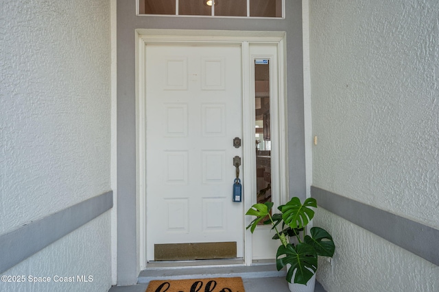 view of exterior entry featuring stucco siding
