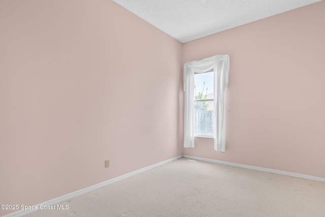 unfurnished room with light carpet and baseboards