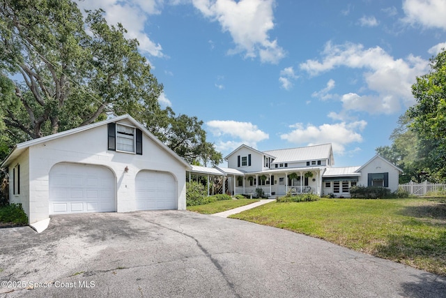 4320 Crooked Mile Rd, Merritt Island, FL 32952 - view of front of home with a porch, a front lawn, fence, and metal roof