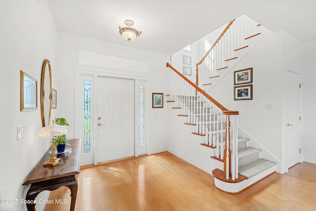 entryway with baseboards, stairs, and hardwood / wood-style floors