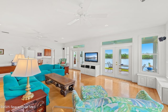 living room featuring a ceiling fan, french doors, and light wood-style flooring