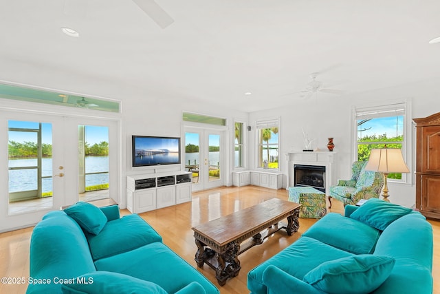living area with a ceiling fan, french doors, recessed lighting, and light wood-style flooring