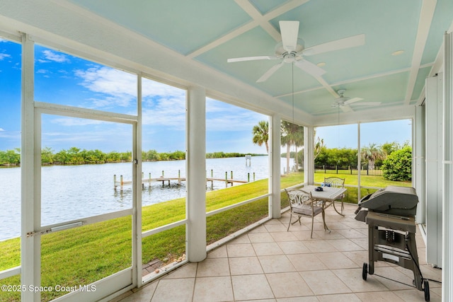 sunroom / solarium featuring a water view and a ceiling fan