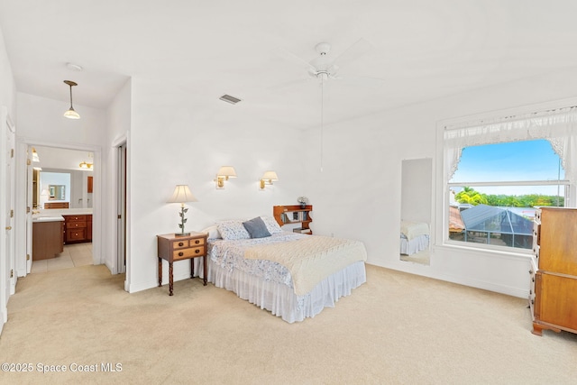 bedroom featuring ceiling fan, light carpet, ensuite bath, baseboards, and visible vents