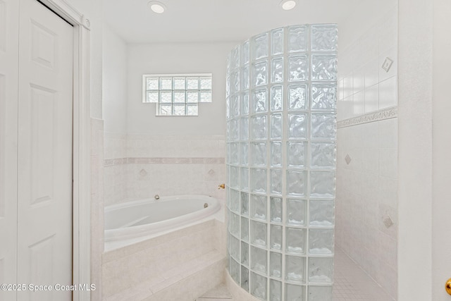 bathroom featuring recessed lighting, walk in shower, and a bath