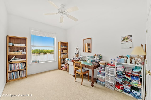 carpeted office with a ceiling fan and baseboards