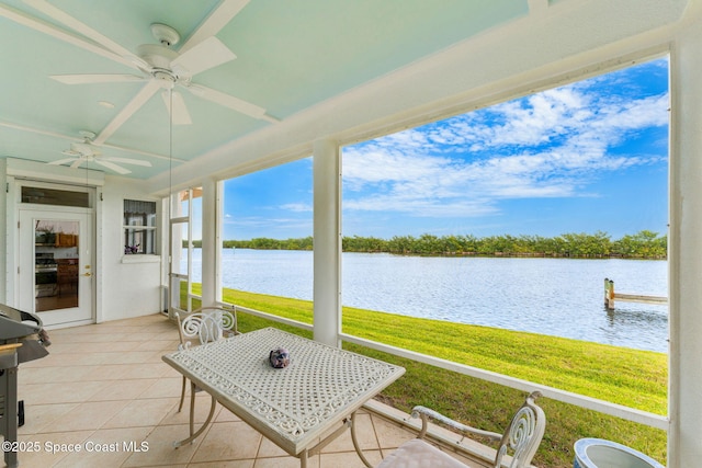 sunroom / solarium with a water view and a ceiling fan