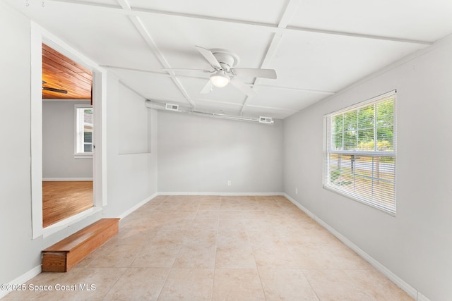 empty room featuring visible vents, a ceiling fan, baseboards, and light tile patterned floors
