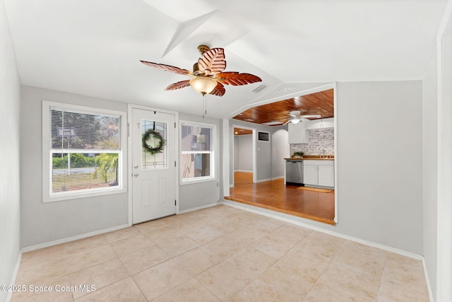 entryway featuring baseboards, ceiling fan, visible vents, and light tile patterned floors