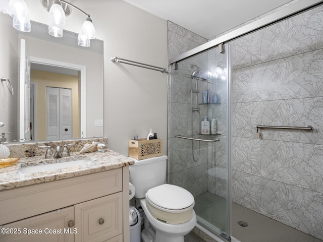 bathroom with toilet, a stall shower, and vanity