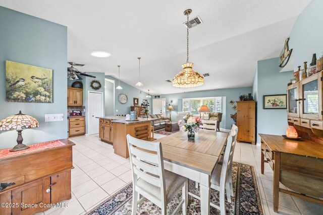 101 Joy Haven Dr, Sebastian, FL 32958 - dining area with lofted ceiling, light tile patterned floors, visible vents, and a ceiling fan