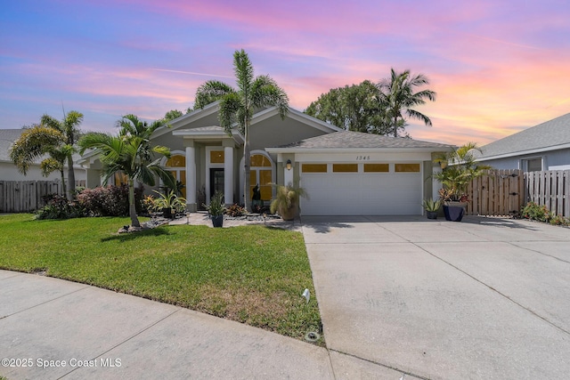 ranch-style house with concrete driveway, a lawn, fence, a garage, and stucco siding