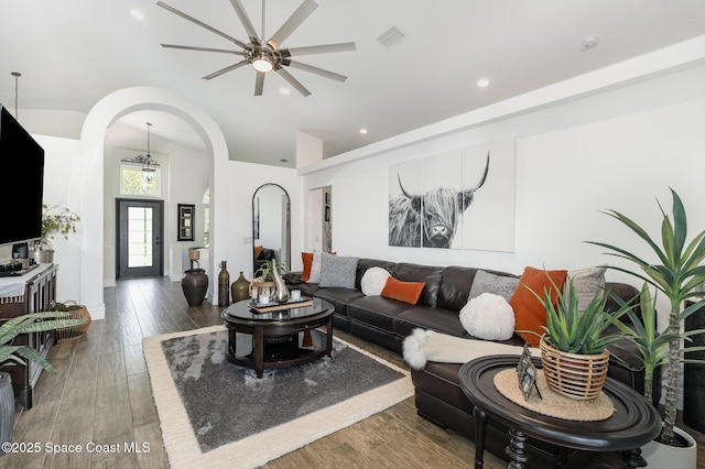 living room featuring recessed lighting, lofted ceiling, wood finished floors, a ceiling fan, and arched walkways