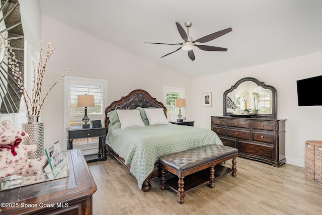 bedroom with light wood-type flooring, vaulted ceiling, and multiple windows