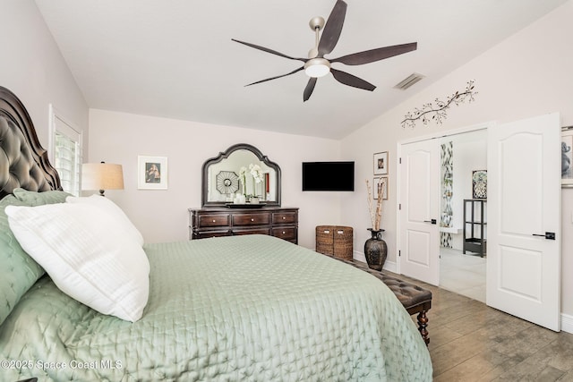 bedroom featuring vaulted ceiling, a ceiling fan, wood finished floors, and visible vents