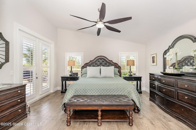 bedroom featuring lofted ceiling, light wood-style flooring, access to outside, and multiple windows