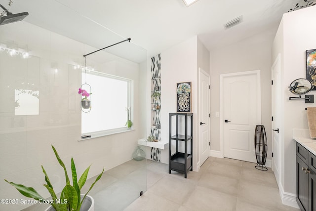 full bath featuring a tile shower, visible vents, tile patterned flooring, and vanity