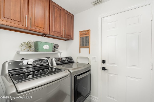 laundry room with washer and dryer, cabinet space, and visible vents