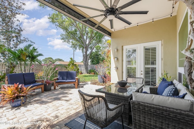 view of patio with a fenced backyard, an outdoor living space, ceiling fan, and french doors