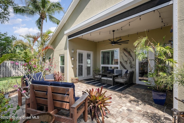 view of patio / terrace with outdoor lounge area, fence, ceiling fan, and french doors