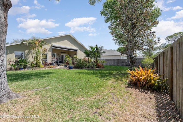 view of yard featuring a ceiling fan and a fenced backyard