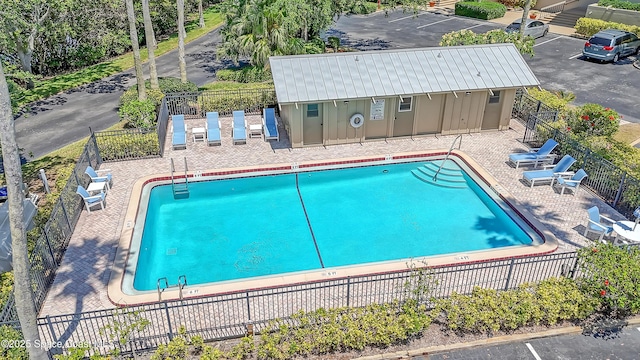 community pool with fence and a patio